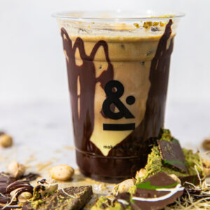 Dubai Chocolate latte with a Ghirardelli dark chocolate cup, finished with pistachios, honey, cold foam, two shots of Yemeni espresso, and kataifi